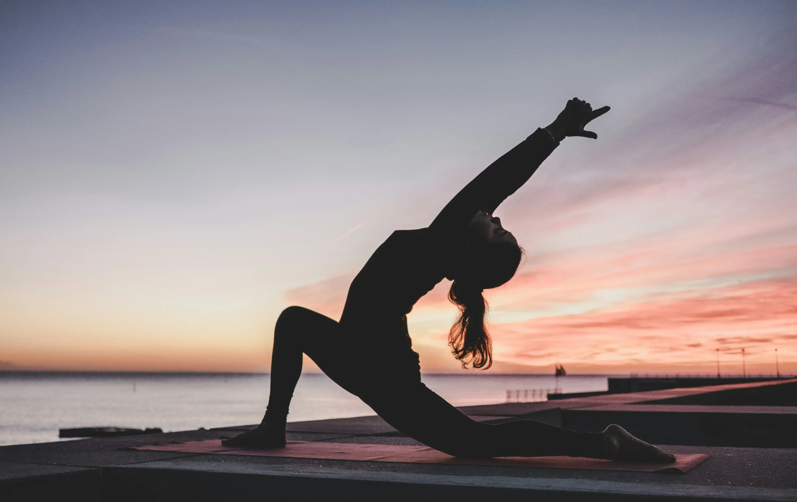 mujer pose de yoga en un muelle